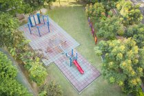 Вид з повітря на порожній дитячий майданчик у зеленому міському парку — стокове фото