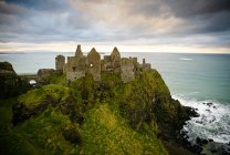 Замок руїни на скелях на березі океану в сонячному світлі, Антрім, округ Антрім, Північна Ірландія — стокове фото