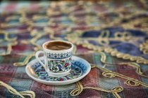 Nahaufnahme einer Tasse türkischen Kaffees auf einer bunten Tischdecke — Stockfoto