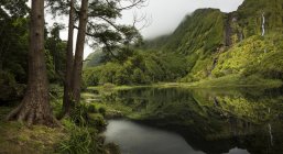 Lago ainda sob montanhas remotas, Ilhas Azore, Portugal — Fotografia de Stock