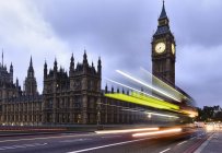 Motion blur of traffic and bus passing Houses of Parliament, Londres, Reino Unido - foto de stock