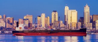 Freighter passing near cityscape, Seattle, Washington, Estados Unidos — Fotografia de Stock