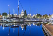 Здания парламента и гавани лодки освещены на рассвете, Виктория, Британская Колумбия, Канада — стоковое фото