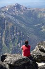 Hiker sitting on rocky hilltop, Washington, USA — Stock Photo