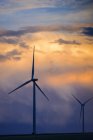 Turbinas eólicas al atardecer bajo paisaje nuboso escénico, Colorado, EE.UU. - foto de stock