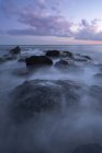 Niebla en las rocas en la orilla del océano, Cape May, Nueva Jersey, EE.UU. - foto de stock