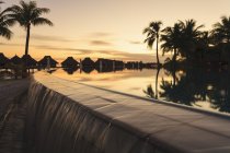 Palm trees overlooking tropical resort at sunset, Bora Bora, French Polynesia — Stock Photo