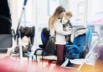 Caucasian mother and baby son shopping in stroller store — стокове фото