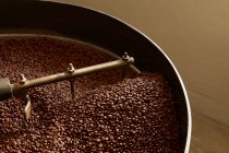 Coffee beans roasting in industrial kettle — Stock Photo
