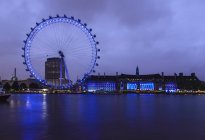 London Eye and waterfront lit up at night, Londres, Reino Unido - foto de stock
