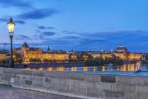 Karlsbrücke und beleuchtete Stadt im Morgengrauen, Prag, Tschechische Republik — Stockfoto
