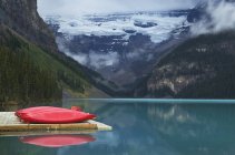 Canoes on wooden dock over still remote lake in Banff, Alberta, Canada — Stock Photo