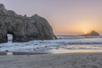 Onde che si riversano sulla spiaggia rocciosa al tramonto, California, USA — Foto stock