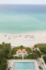 Високий кут зору готельний басейн і пляж зі стільцями і туристів — стокове фото
