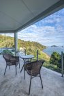 Mesa y sillas en balcón con vistas a la Bahía de las Islas, Paihia, Nueva Zelanda - foto de stock