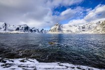 Snowy mountains overlooking ocean, Reine, Lofoten Islands, Norway — Stock Photo