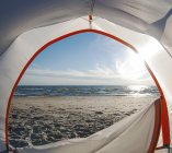 Open camping tent door on beach with backlit — Stock Photo