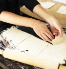 Mãos de padeiro fêmea cortando massa de torta em quadrados — Fotografia de Stock
