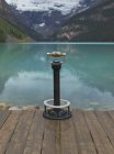 Binoculars overlooking still lake in rural landscape in Banff, Alberta, Canada — Stock Photo