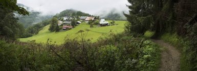 Village in green hills, Les Houcheas, Francia - foto de stock
