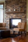 Chairs and fireplace in living room — Stock Photo
