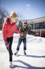 Young Caucasian couple ice skating on frozen lake in winter — Stock Photo