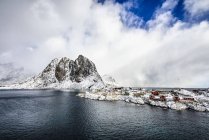Montagnes enneigées surplombant le littoral rocheux, Reine, Îles Lofoten, Norvège — Photo de stock