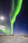 Northern lights in sky over snowy landscape in Vik, Iceland — Stock Photo