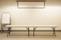Mesas vazias sob tela de projetor em sala de aula — Fotografia de Stock