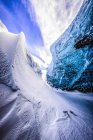 Стеклянная стена заснеженной голубой ледяной пещеры — стоковое фото
