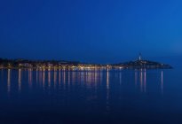 Reflexão iluminada da cidade costeira em águas tranquilas, Rovinj, Ístria, Croácia — Fotografia de Stock