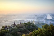 Vista aérea de antiguas torres en el paisaje brumoso de Myanmar - foto de stock