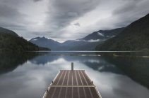 Metal pier over still remote lake — Stock Photo