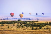 Heißluftballons fliegen über Savannenlandschaft, Kenia, Afrika — Stockfoto