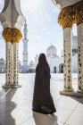 Donna che cammina a Sheikh Zayed Grand Mosque, Abu Dhabi, Emirati Arabi Uniti — Foto stock