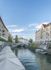 Buildings and pedestrian bridge over urban canal, Ljubljana, Central Slovenia, Slovenia — Stock Photo