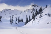 Silhouette of man hiking in snowy mountains overlooking Heather Meadows, Washington, United States — Stock Photo