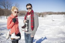 Молодая кавказская пара с коньками зимой — стоковое фото