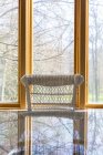 Окно за плетеным стулом и стеклянным столом — стоковое фото