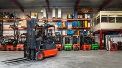 Forklift machinery parked in a row in warehouse — Stock Photo