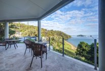 Table and chairs on balcony overlooking Bay of Islands, Paihia, New Zealand — Stock Photo