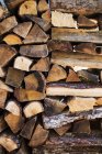 Vollständiger Rahmen aus rustikal gestapelten Brennholzstämmen. — Stockfoto