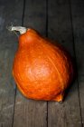 Close-up of orange Hubbard pumpkin on rustic wooden table. — Stock Photo