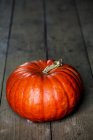 Close-up of bright orange pumpkin on rustic wooden table. — Stock Photo