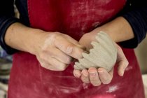 Midsection de artista de cerâmica em avental vermelho trabalhando em tigela de argila pequena . — Fotografia de Stock