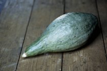 Close-up of green pumpkin on rustic wooden table. — Stock Photo