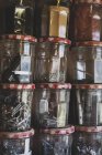 Close-up de pilha de frascos de geléia contendo seleção de pregos e parafusos . — Fotografia de Stock