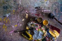 High angle close-up of palette, oil paints and paintbrush in workshop. — Stock Photo