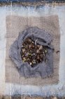 Крупный план коричневых луковых луковиц на мешковидной ткани на сером фоне . — стоковое фото