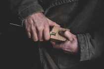 Alto ângulo close-up de homem montagem de peça de metal em bloco de madeira . — Fotografia de Stock